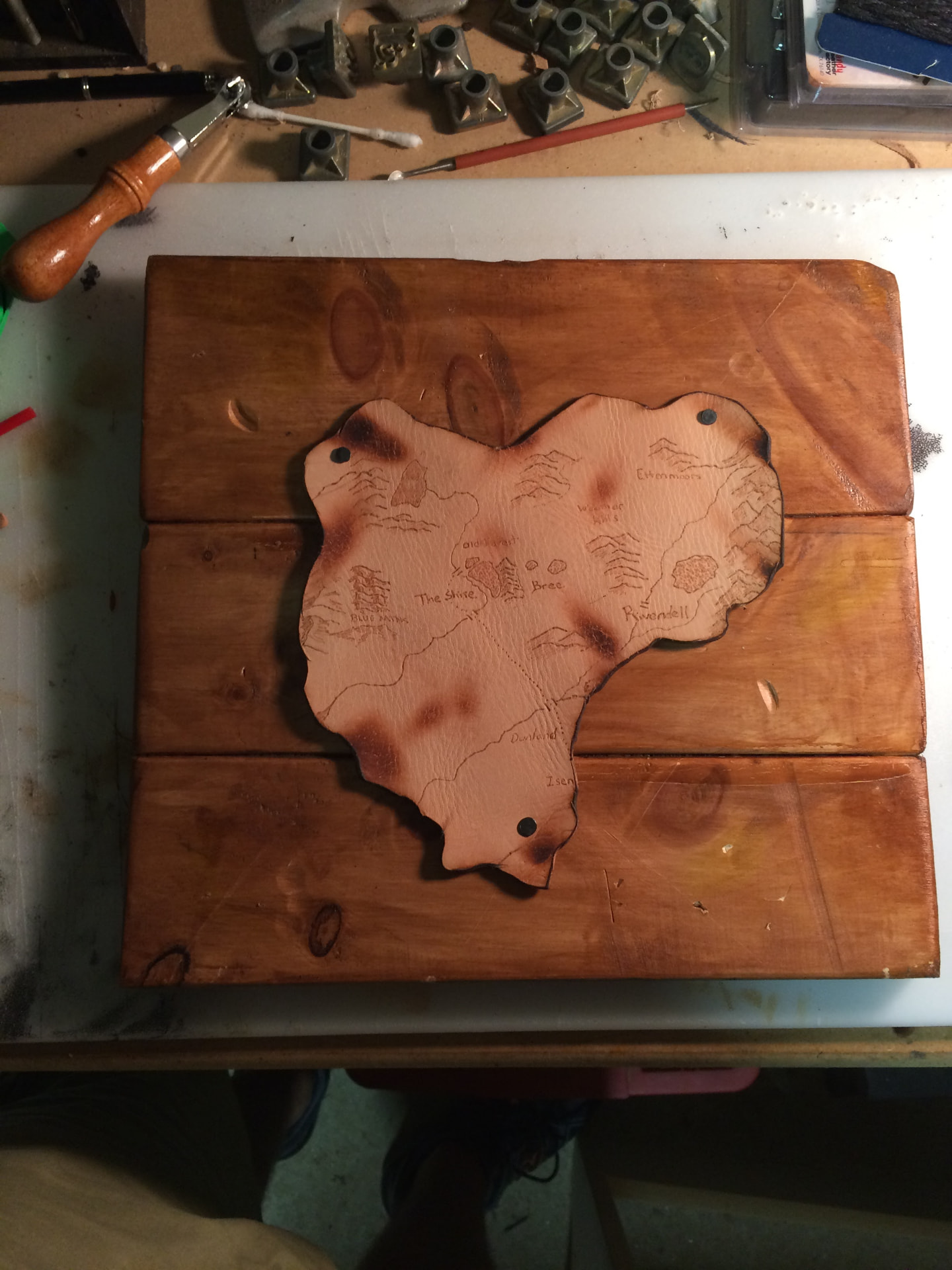 Middle-earth map burned into leather and tacked onto a stained wood board