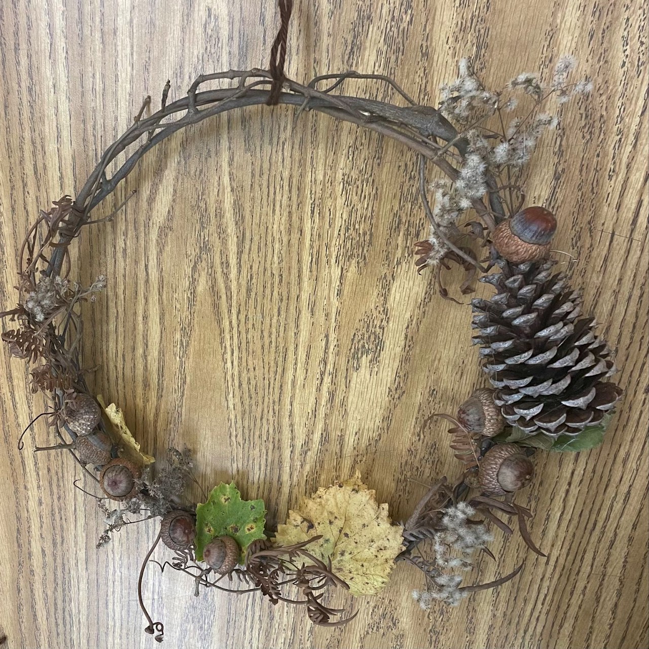 Foraged wreath made with vine, acorns, pine cone, and dried leaves